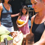 Mindy Hibbitt and her daughter Lea of Koloa enjoy fresh coconut prepared by Natalie Urminska of Moloa'a