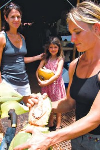Mindy Hibbitt and her daughter Lea of Koloa enjoy fresh coconut prepared by Natalie Urminska of Moloa'a