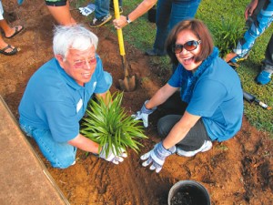 Farmers employees Alfonso Lopez and Carmen Quisisem plant a palm tree