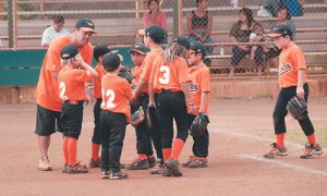 Orioles coach Justin Molina encourages his team between innings